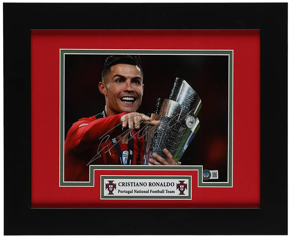 Cristiano Ronaldo signed 8x10 photo smiling with the UEFA Nations League trophy in the red Portugal kit, with a Beckett hologram on the photo, in a black frame with red and green matting and a Portugal nameplate