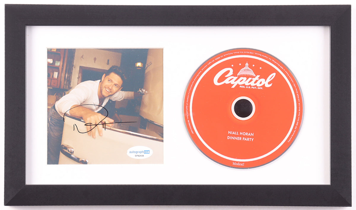 Niall Horan signed Dinner Party framed CD display: color photo insert of Horan leaning on a vintage white appliance, signed in black marker with the ACOA label, beside the red Capitol label album disc in a white mat and black frame