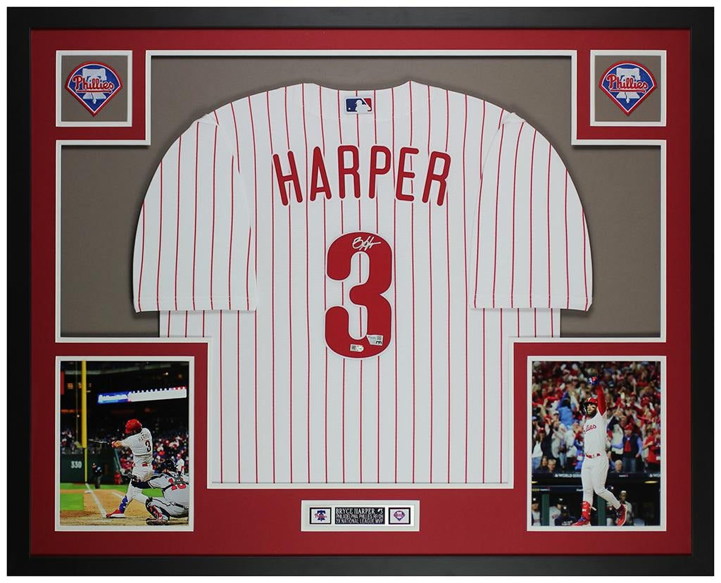 Bryce Harper signed Philadelphia Phillies #3 pinstriped home jersey in a custom frame with red and gray mat, two Phillies logo patches, two action photos and an engraved nameplate