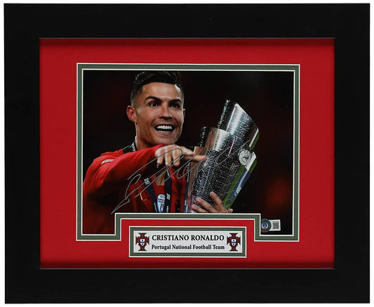 Cristiano Ronaldo signed 8x10 photo smiling with the UEFA Nations League trophy in the red Portugal kit, with a Beckett hologram on the photo, in a black frame with red and green matting and a Portugal nameplate