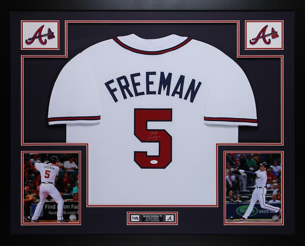 Freddie Freeman signed Atlanta Braves #5 white home jersey in a custom frame with navy mat, red and white trim, two Braves logo patches, two batting photos and an engraved nameplate