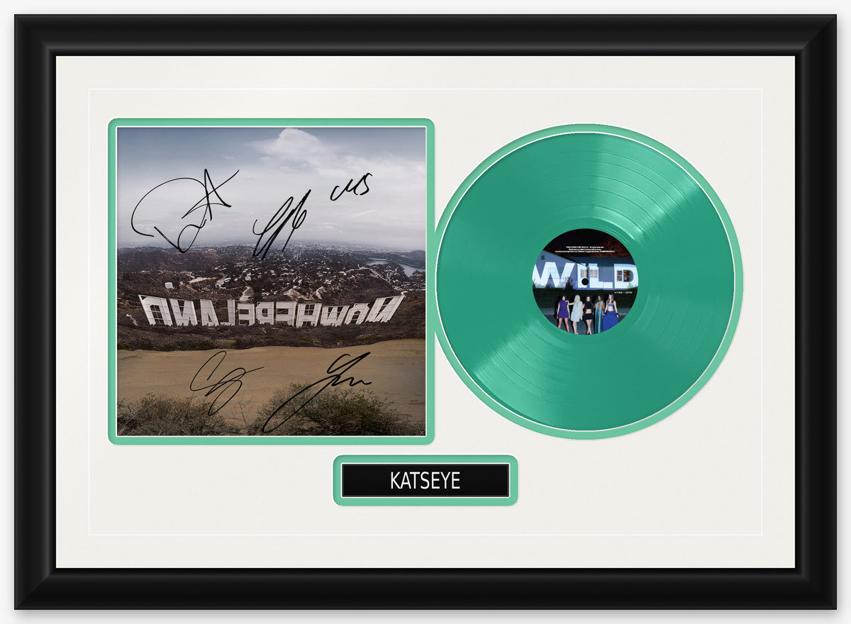 KATSEYE signed WILD insert card, a hillside sign photo signed in black marker, framed beside the green WILD LP in a black frame with white matting, green reveals and a black KATSEYE nameplate