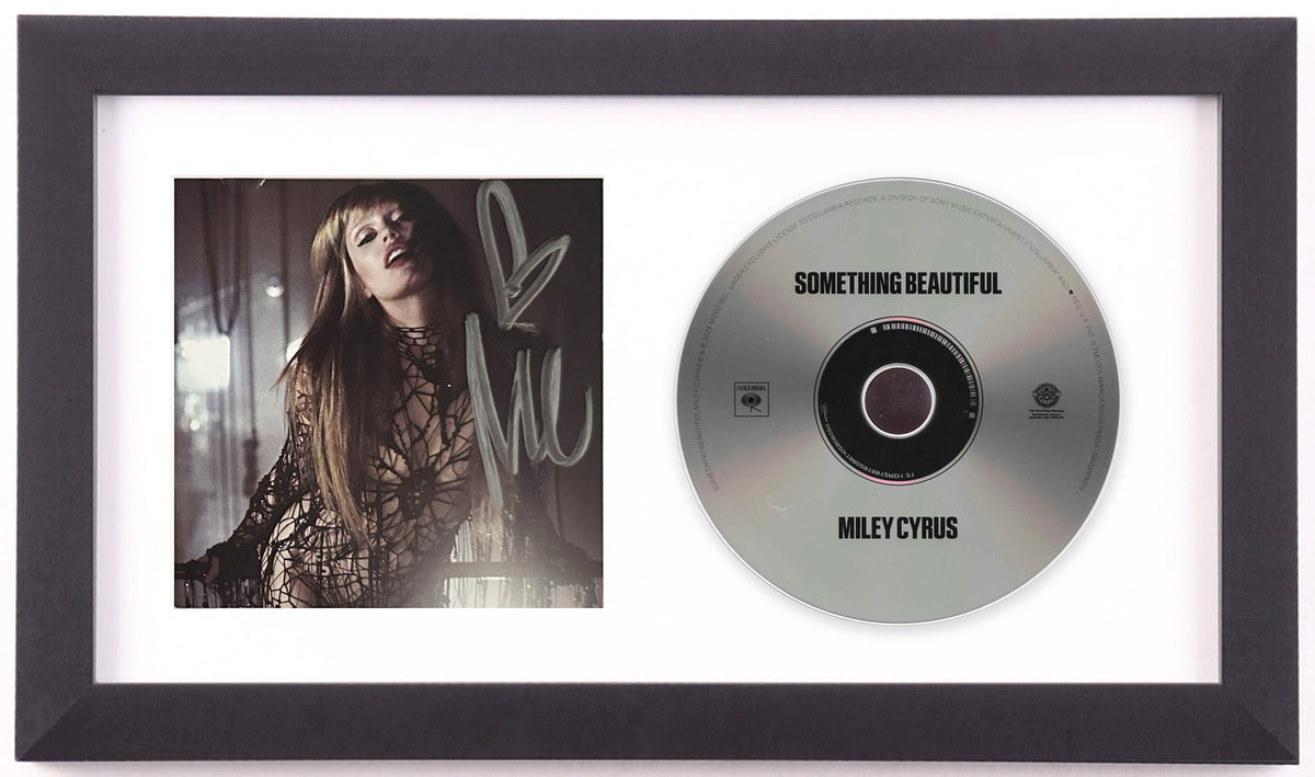 Miley Cyrus signed Something Beautiful framed CD display preview: signed photo insert of Cyrus in black lace, beside the silver album disc, in a white mat and black frame