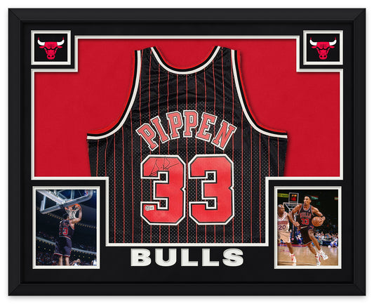 Scottie Pippen signed black pinstripe Chicago Bulls number 33 jersey in a black frame with black matting, red backing, Bulls logos, two photos of Pippen and BULLS lettering