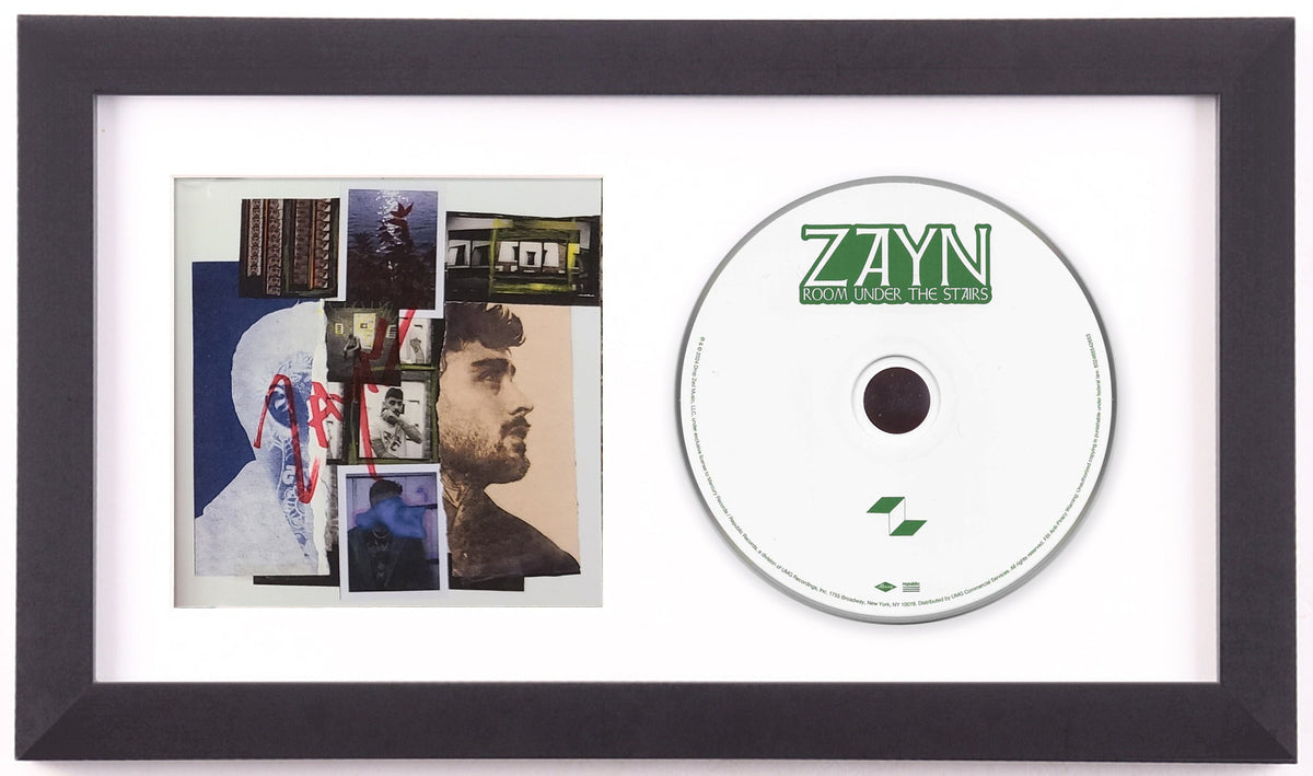 ZAYN signed Room Under the Stairs framed CD display preview: signed collage art card of photographs and torn paper, beside the white album disc with the green ZAYN wordmark, in a white mat and black frame